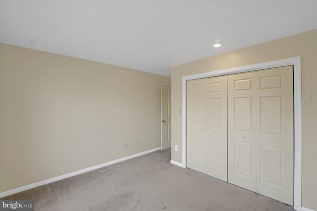 unfurnished bedroom with carpet floors, a closet, and baseboards