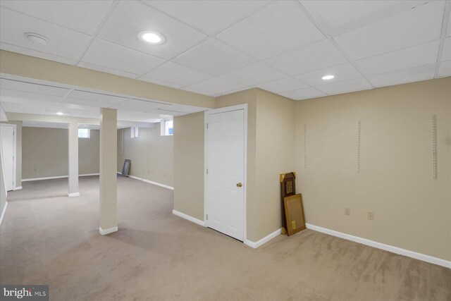 basement with baseboards, carpet flooring, a drop ceiling, and recessed lighting