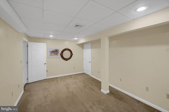 finished basement featuring a drop ceiling, carpet, visible vents, and baseboards