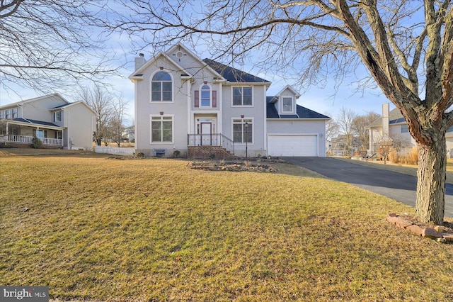 view of front facade featuring aphalt driveway, a front lawn, a chimney, and a garage