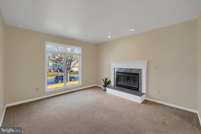 unfurnished living room featuring a fireplace, carpet flooring, and baseboards