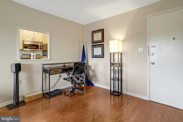 office area featuring baseboards and wood finished floors