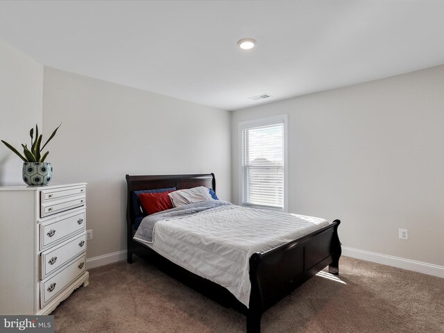 carpeted bedroom with visible vents and baseboards