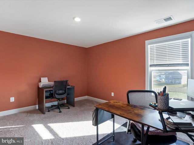 carpeted office space featuring visible vents and baseboards