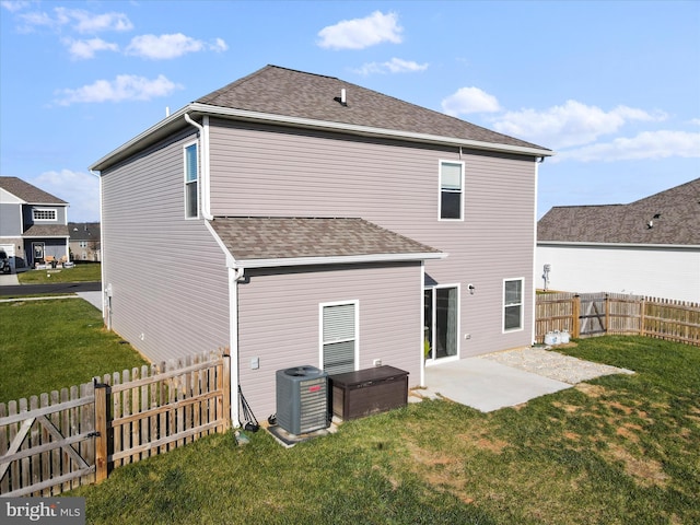 back of property with roof with shingles, a fenced backyard, central air condition unit, a patio area, and a lawn