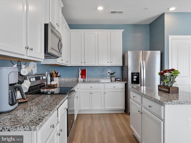 kitchen featuring visible vents, white cabinets, appliances with stainless steel finishes, and light wood-type flooring