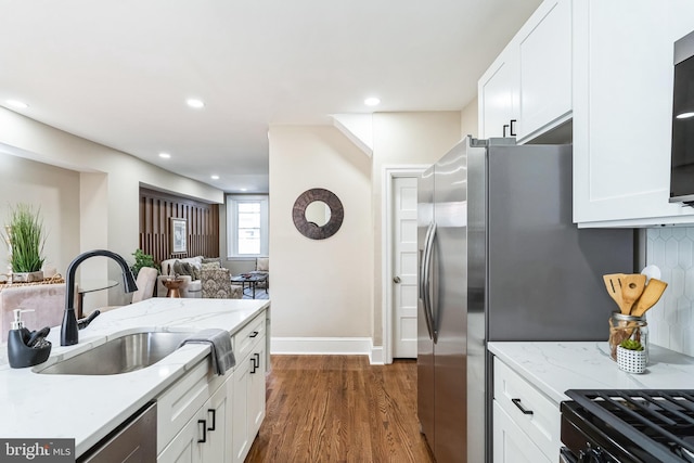 kitchen featuring white cabinets, dark wood finished floors, a sink, and recessed lighting