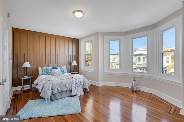 bedroom with wood finished floors and baseboards