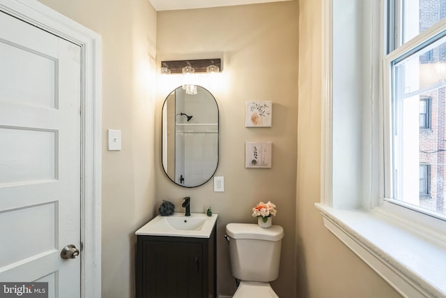 bathroom featuring a healthy amount of sunlight, vanity, and toilet