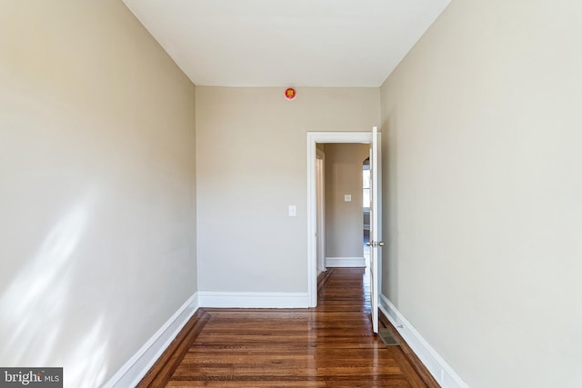 empty room with baseboards and wood finished floors