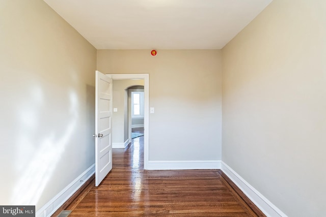 unfurnished room with baseboards and wood finished floors