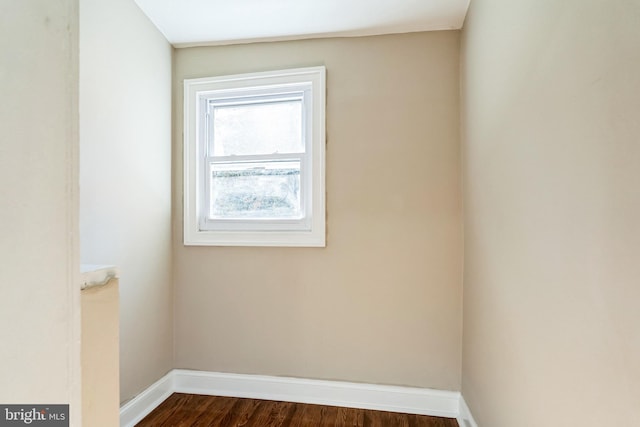 unfurnished room with dark wood-style floors and baseboards