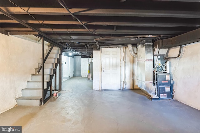 unfinished basement featuring heating unit, water heater, and stairway