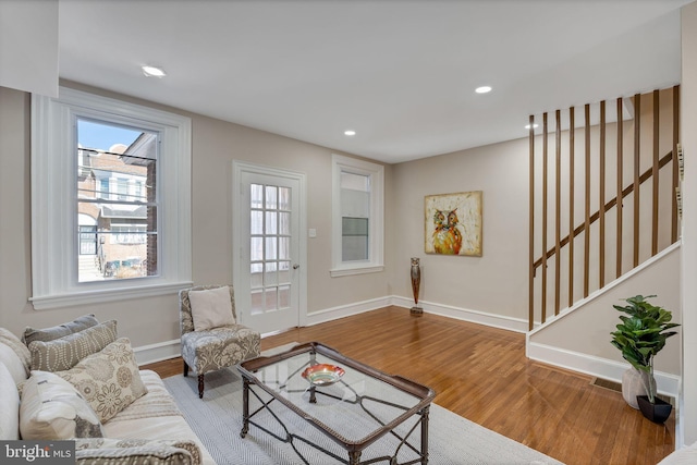 living area featuring stairs, recessed lighting, wood finished floors, and baseboards