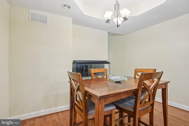 dining space with visible vents, baseboards, light wood finished floors, a notable chandelier, and recessed lighting