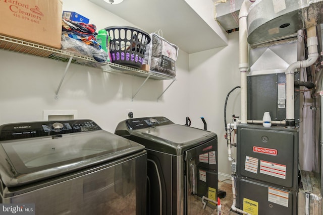 laundry area featuring laundry area, heating unit, independent washer and dryer, and baseboards