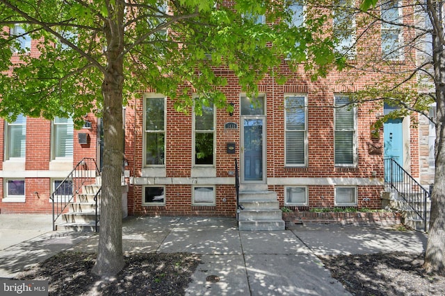 townhome / multi-family property with entry steps and brick siding