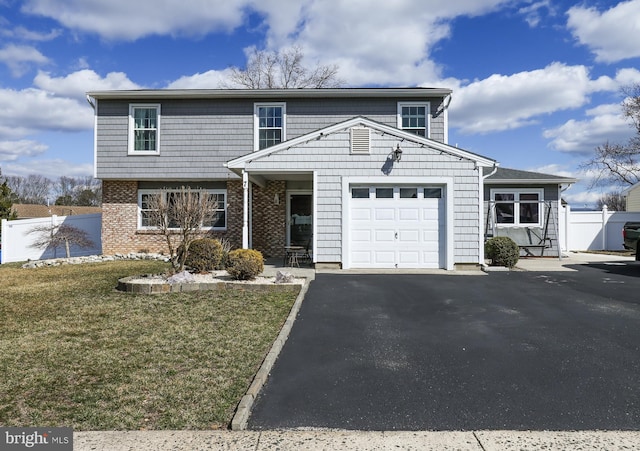 view of front of home with driveway, an attached garage, fence, a front lawn, and brick siding