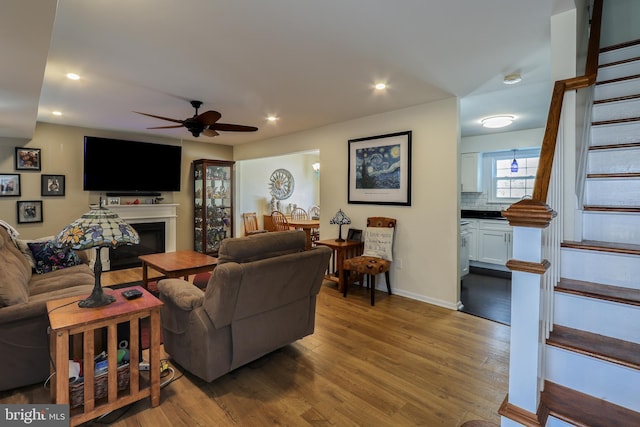 living area with stairs, ceiling fan, wood finished floors, and recessed lighting