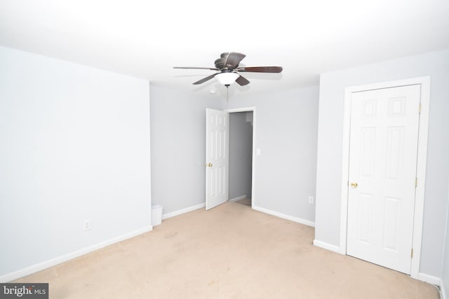 unfurnished bedroom with baseboards, a ceiling fan, and light colored carpet