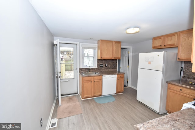 kitchen with white appliances, a sink, visible vents, light wood-style floors, and decorative backsplash