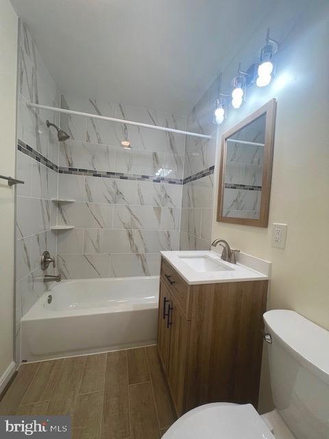 bathroom featuring bathing tub / shower combination, toilet, and vanity