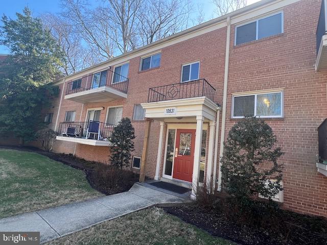 view of front of property with a front yard and brick siding