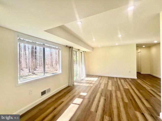 interior space with baseboards, visible vents, wood finished floors, and recessed lighting