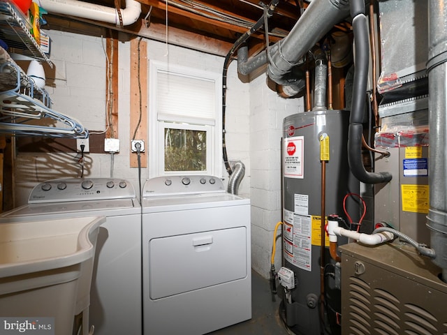 laundry room featuring gas water heater, laundry area, a sink, heating unit, and washer and clothes dryer