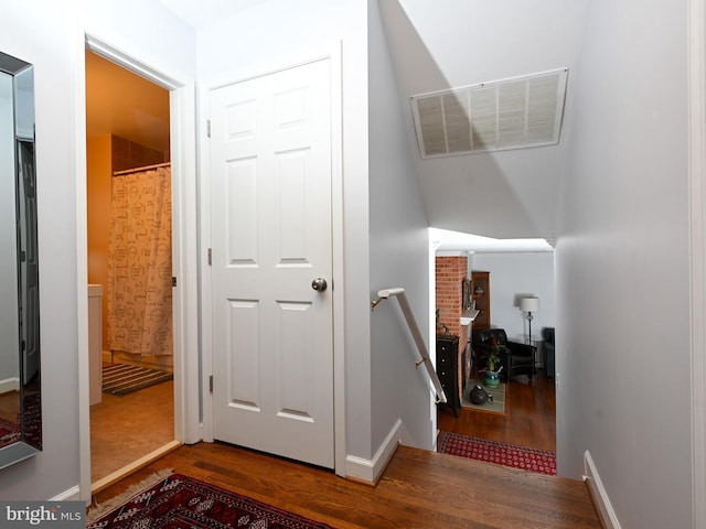 stairway featuring wood finished floors, visible vents, and baseboards