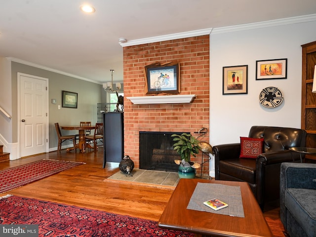 living room featuring baseboards, stairway, wood finished floors, crown molding, and a brick fireplace