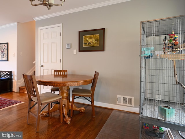 dining space with baseboards, visible vents, wood finished floors, stairs, and crown molding