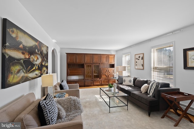 living room featuring arched walkways and a baseboard radiator