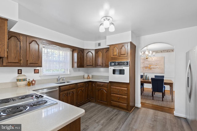 kitchen featuring stainless steel appliances, a sink, visible vents, light countertops, and light wood finished floors