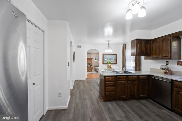 kitchen with dark wood-style flooring, stainless steel appliances, light countertops, visible vents, and dark brown cabinets