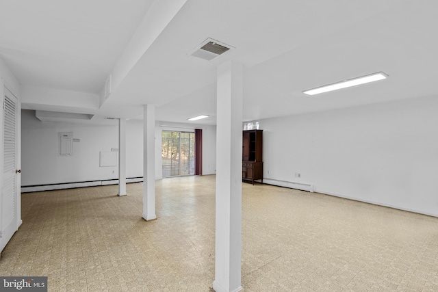 basement with visible vents, baseboard heating, and tile patterned floors