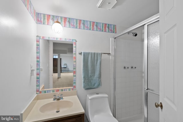 bathroom with toilet, a shower stall, and vanity