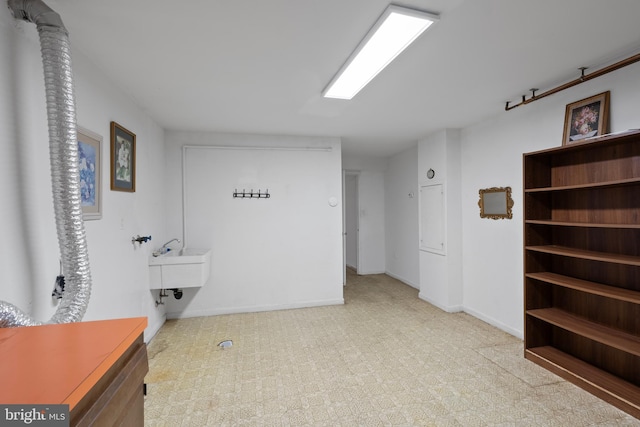 interior space with laundry area, hookup for a washing machine, baseboards, and a sink