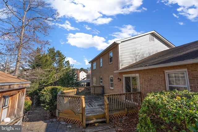 back of house featuring a deck and brick siding