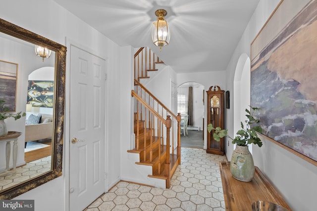 entrance foyer featuring arched walkways and stairway