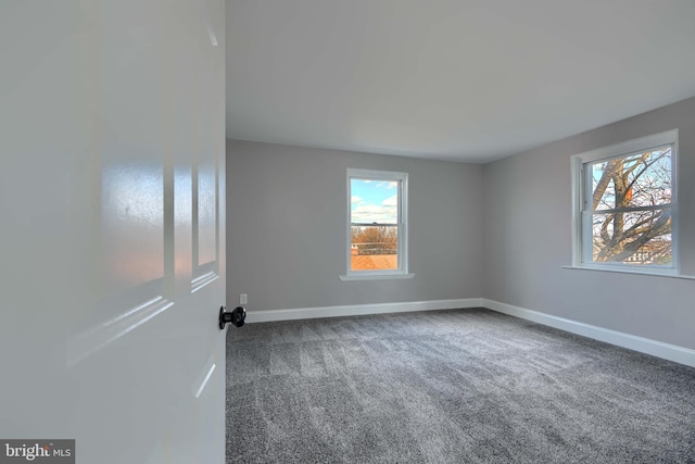 carpeted spare room with baseboards