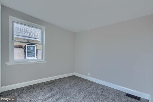 carpeted spare room with visible vents, plenty of natural light, and baseboards