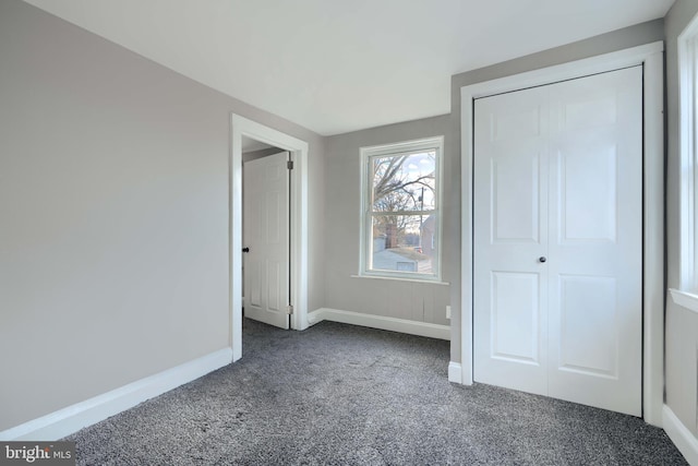 unfurnished bedroom with carpet flooring, baseboards, and a closet