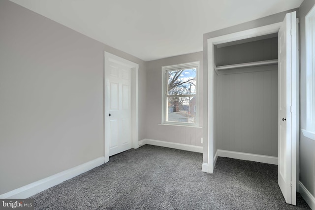 unfurnished bedroom featuring a closet, baseboards, and carpet