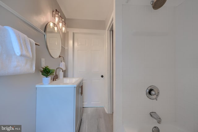 full bath with tub / shower combination, vanity, and wood finished floors