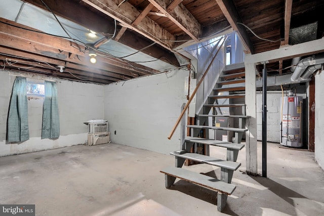 basement featuring water heater, stairway, and a wall unit AC