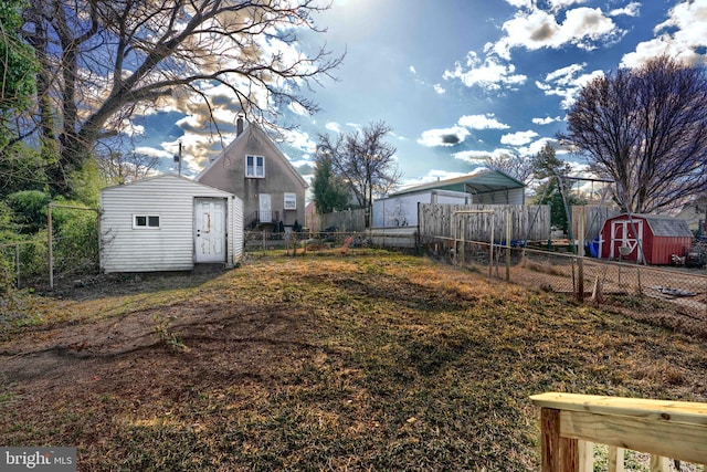 view of yard featuring an outbuilding, a storage shed, and fence