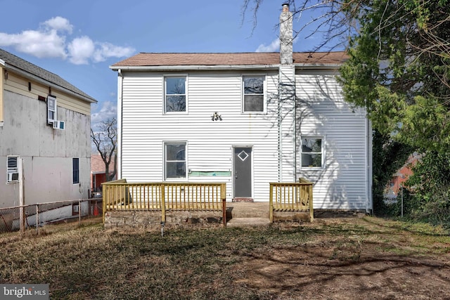 rear view of property with fence and a wooden deck