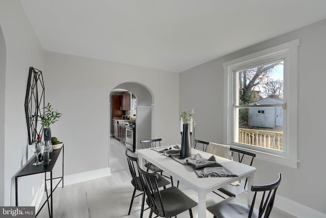 dining area featuring baseboards and arched walkways