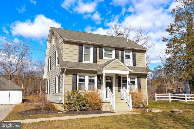 view of front of house with a shingled roof, a front lawn, fence, and a chimney